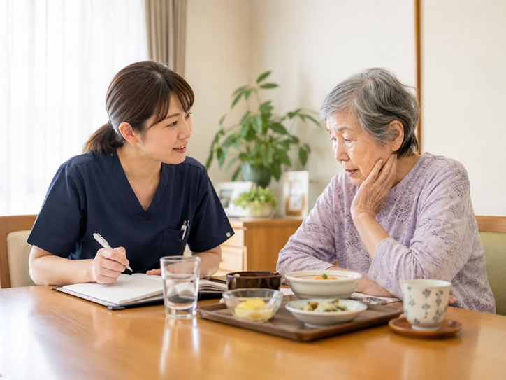 訪問看護師が食事量や水分量の変化について利用者と確認している様子