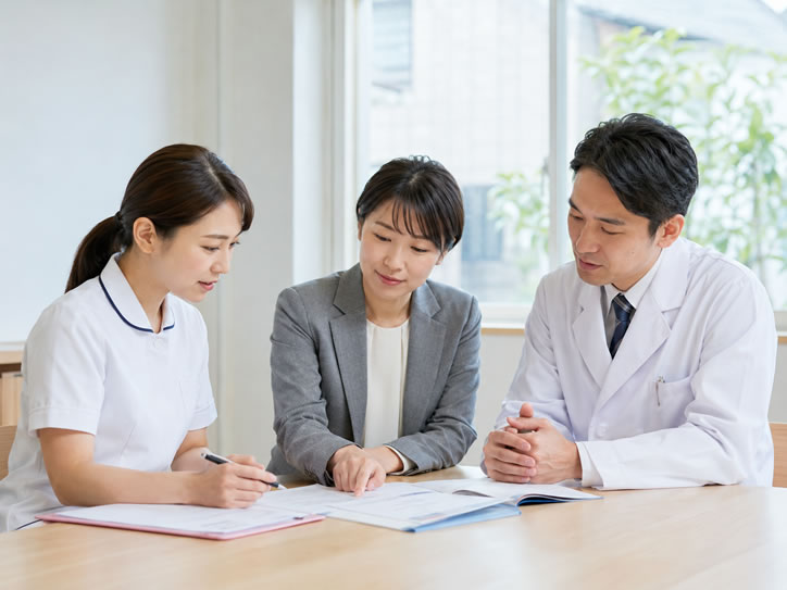 看護師とケアマネジャーと医師が連携の打ち合わせをしている様子